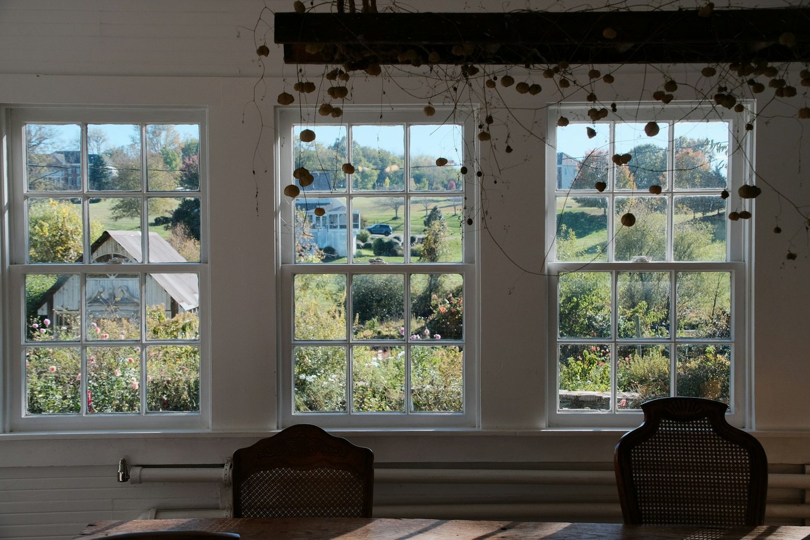Fensterflügel liegt leicht geöffnet am Rahmen an, während eine Hand den Griff hält