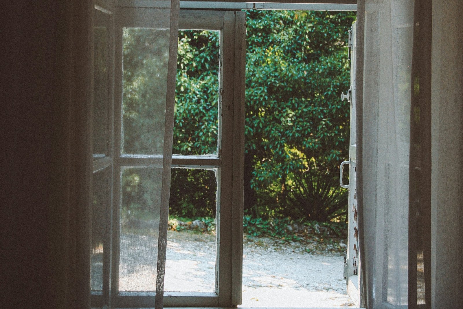 Handwerker arbeitet am geöffneten Fensterrahmen mit sichtbarem Beschlag