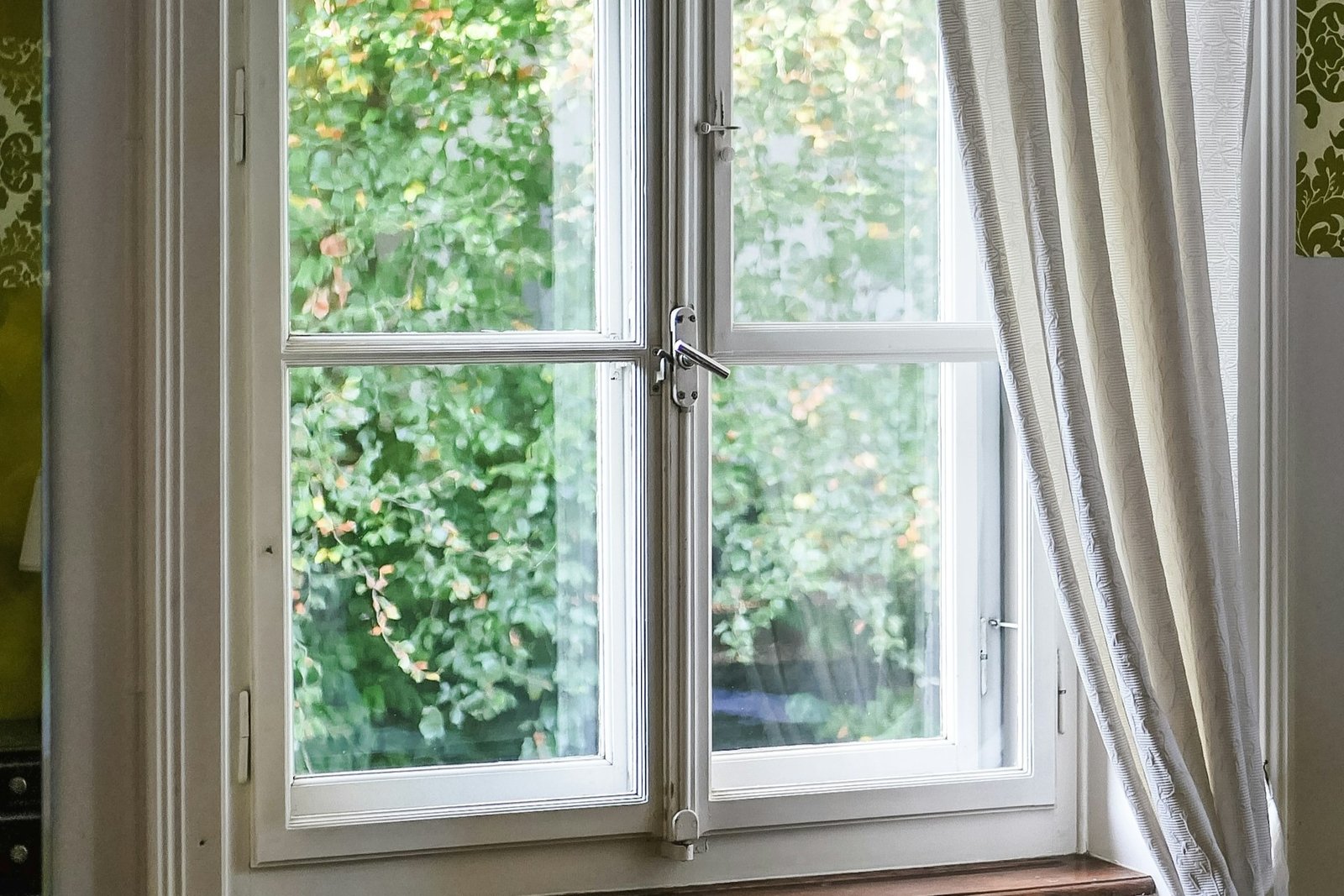 Fenstergriff in schräger 45-Grad-Stellung an einem weißen Fensterrahmen