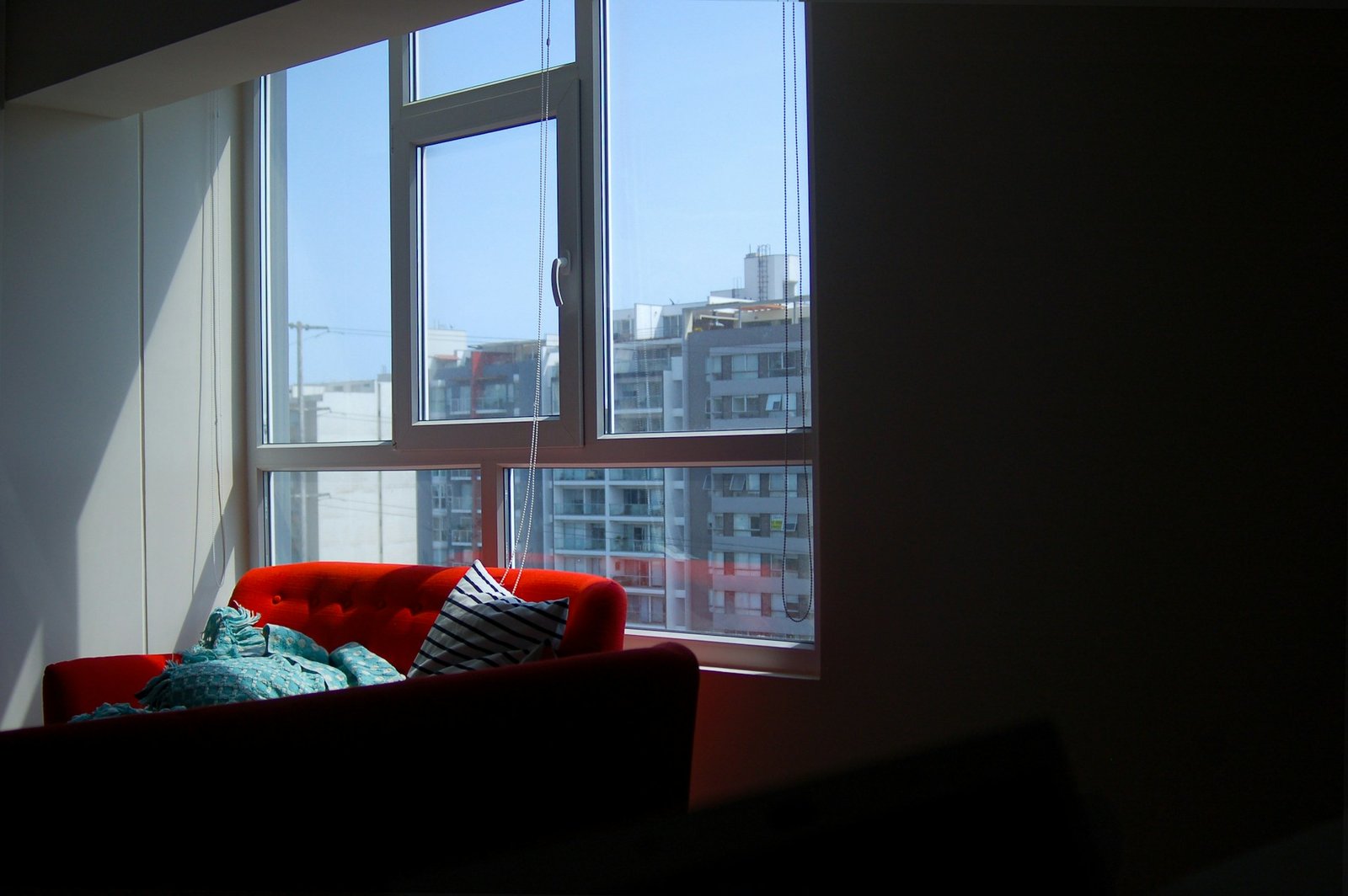 Hand dreht einen Fenstergriff in einer Wohnung am weißen Fensterrahmen