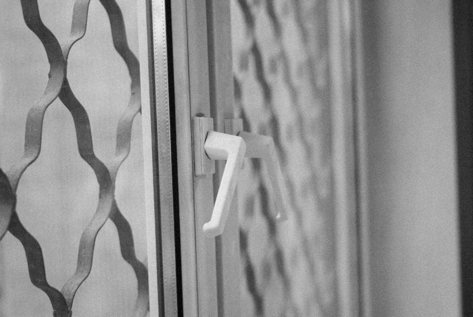 Abmontierter Fenstergriff mit sichtbaren Schrauben und Schraublöchern im Rahmen