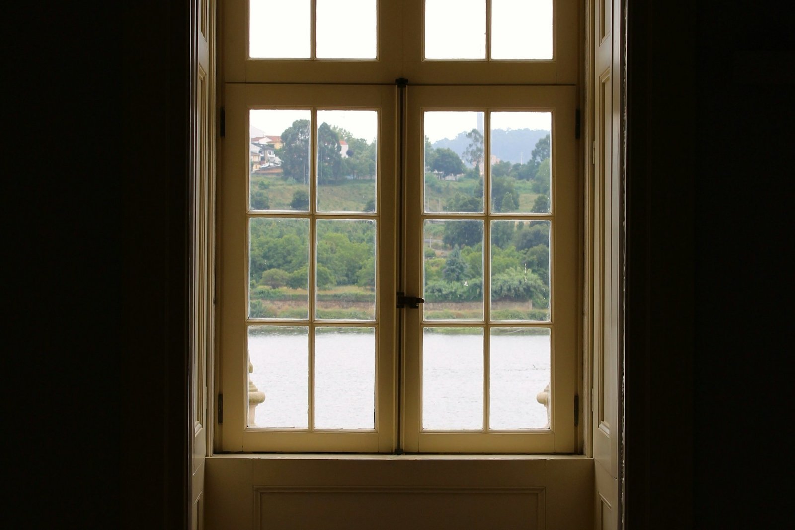 Hand dreht einen schwergängigen Fenstergriff am geschlossenen Fenster