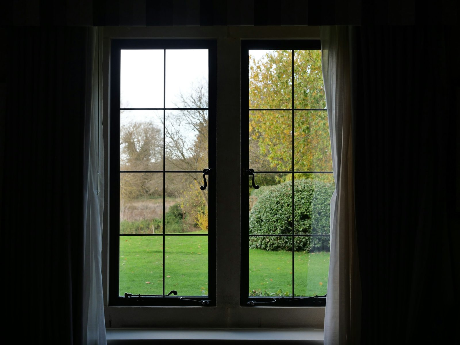 Hand schraubt einen Fenstergriff am Rahmen ab