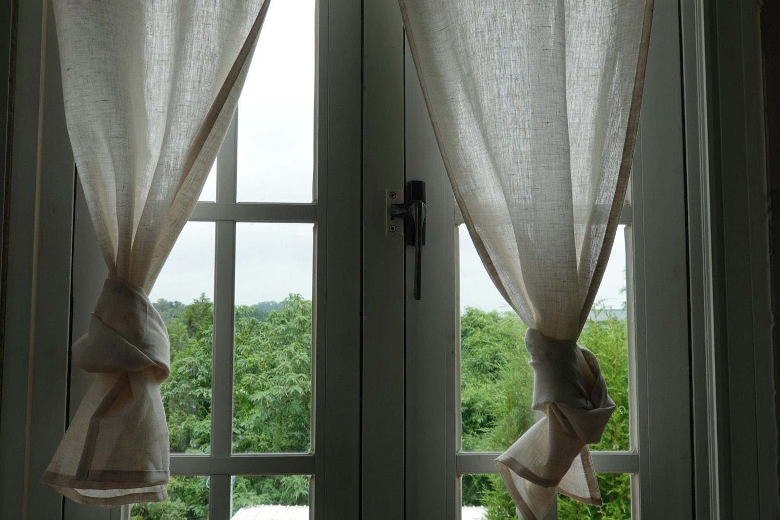 Gebrochener metallischer Vierkantstift neben einem Fenstergriff auf hellem Untergrund